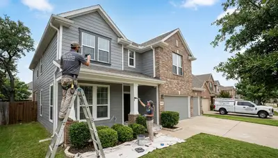 Professional house painters working on residential exterior in Arlington TX